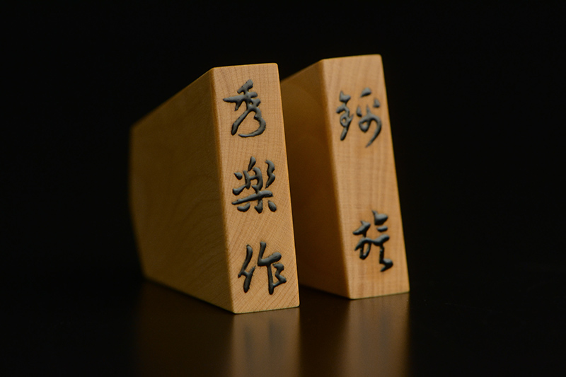 盛上げで玉将の駒尻に「秀楽作」、王将の駒尻に「菱湖」