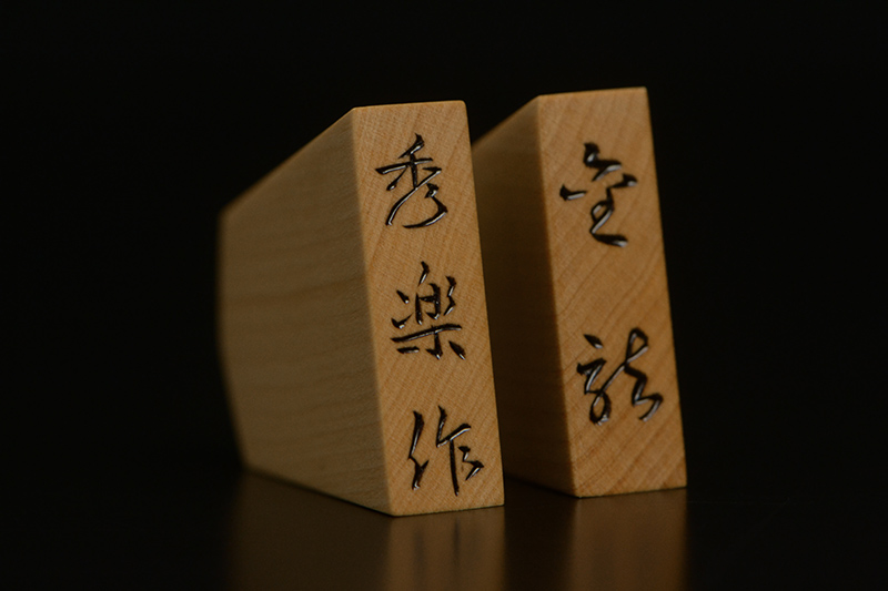 盛上げで玉将の駒尻に「秀楽作」、王将の駒尻に「菱湖」