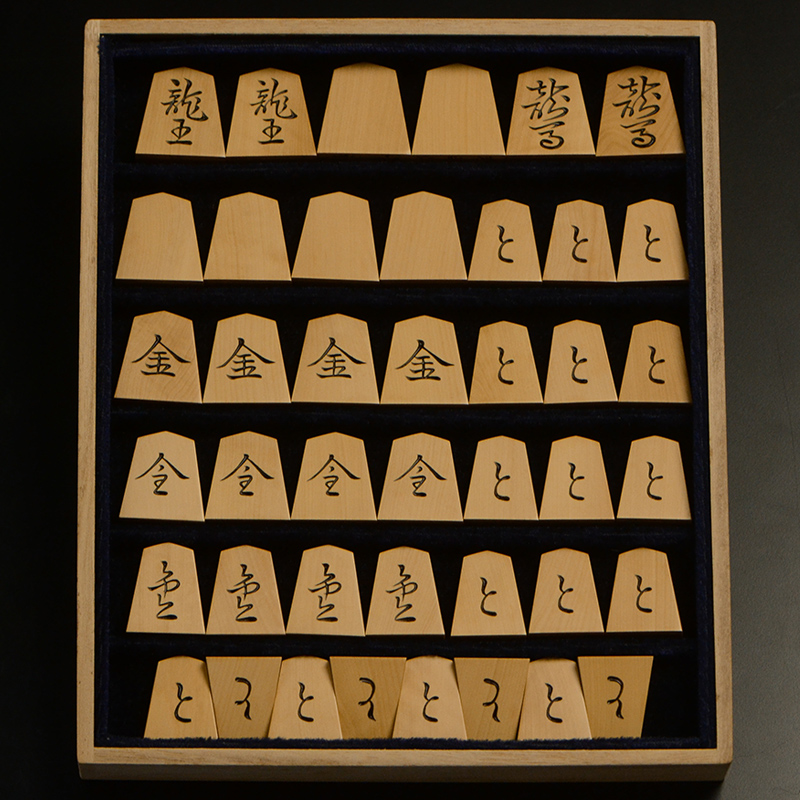 平箱に入った、裏返した将棋駒すべて