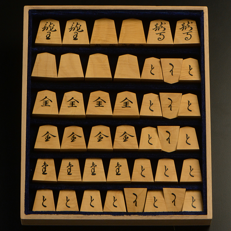 平箱に入った、裏返した将棋駒すべて