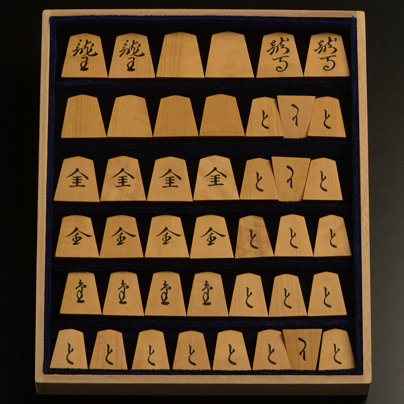 平箱に入った、裏返した将棋駒すべて