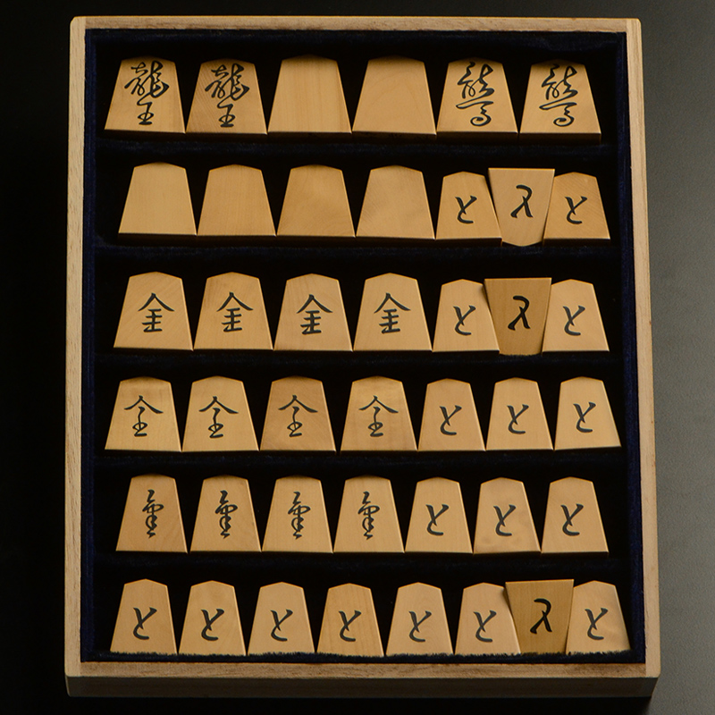 平箱に入った、裏返した将棋駒すべて