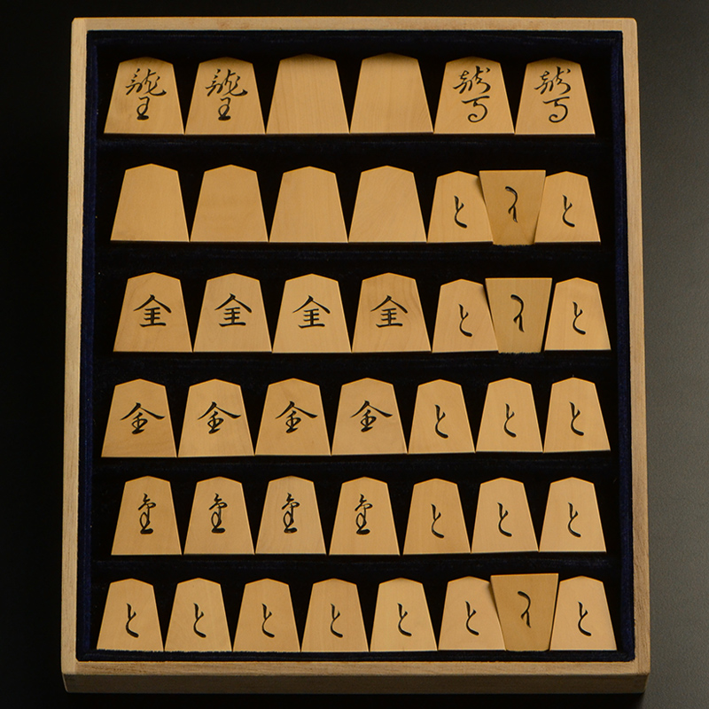 平箱に入った、裏返した将棋駒すべて