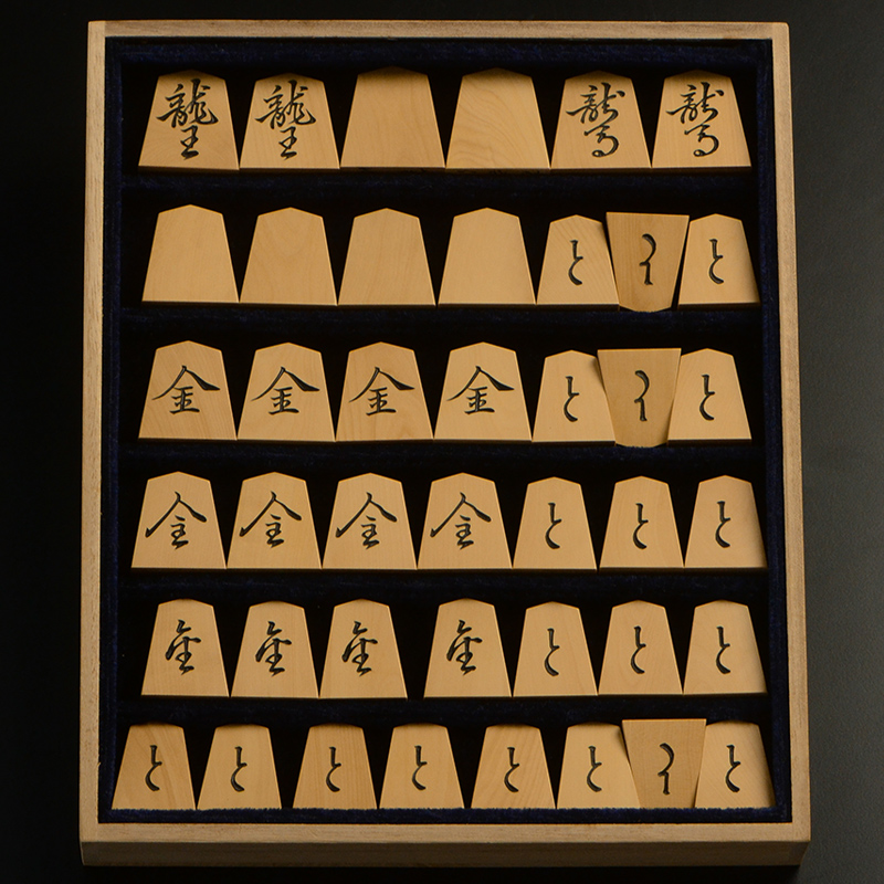 平箱に入った、裏返した将棋駒すべて