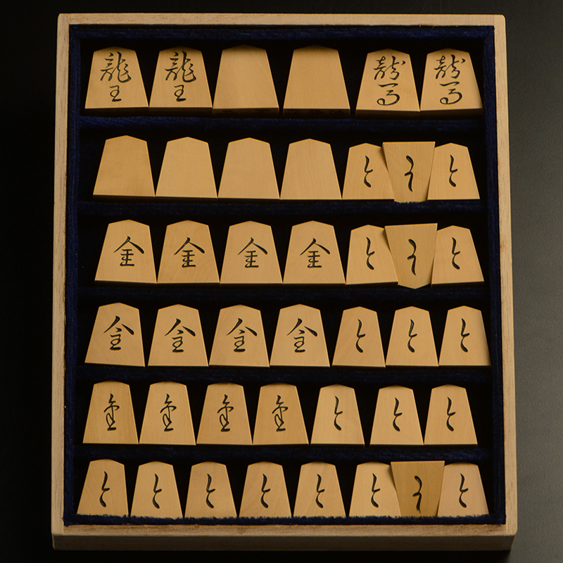 平箱に入った、裏返した将棋駒すべて