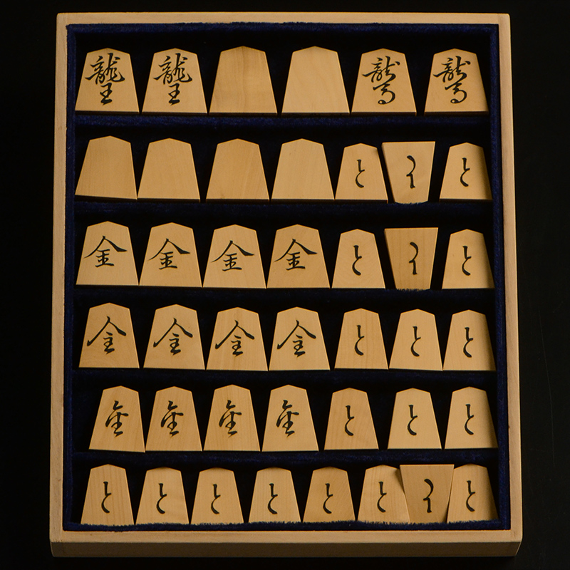 平箱に入った、裏返した将棋駒すべて