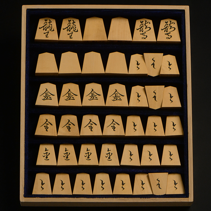 平箱に入った、裏返した将棋駒すべて