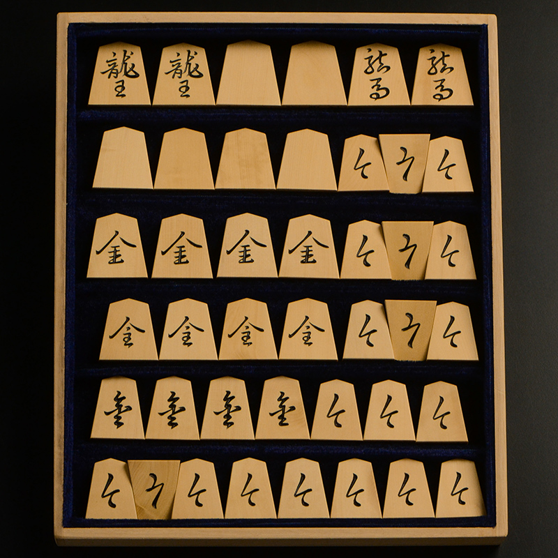 平箱に入った、裏返した将棋駒すべて