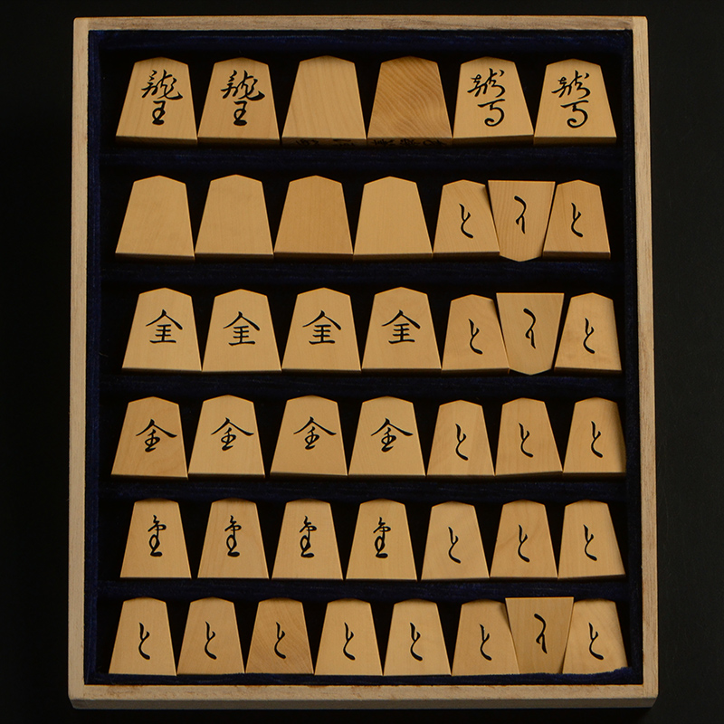 平箱に入った、裏返した将棋駒すべて