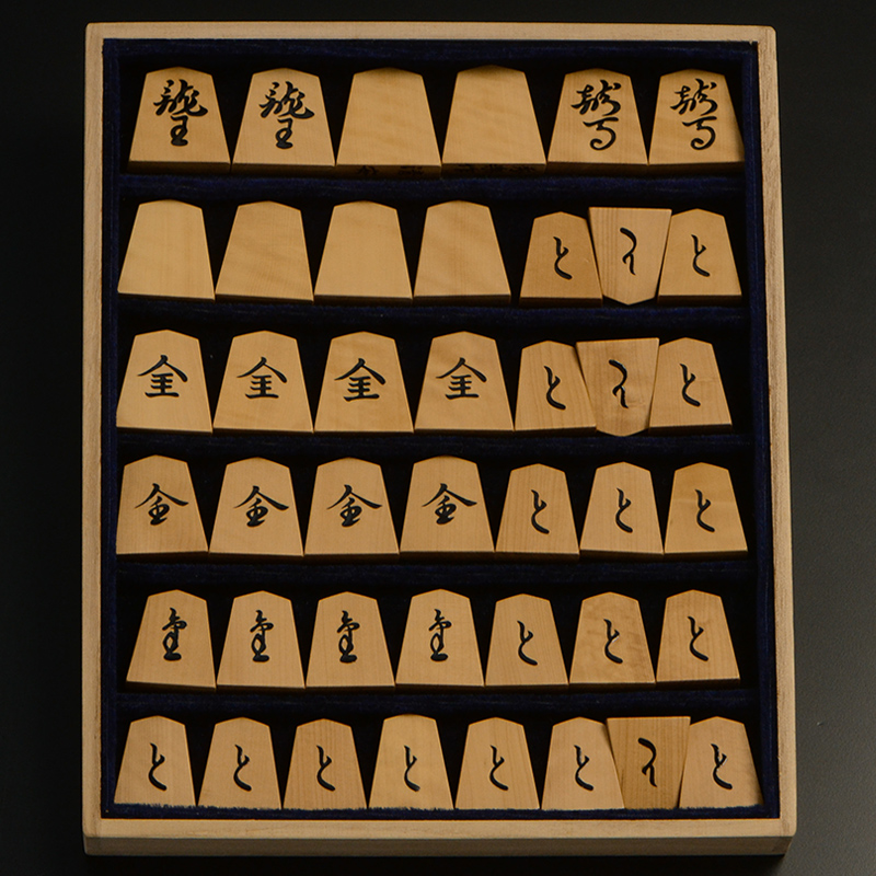 平箱に入った、裏返した将棋駒すべて