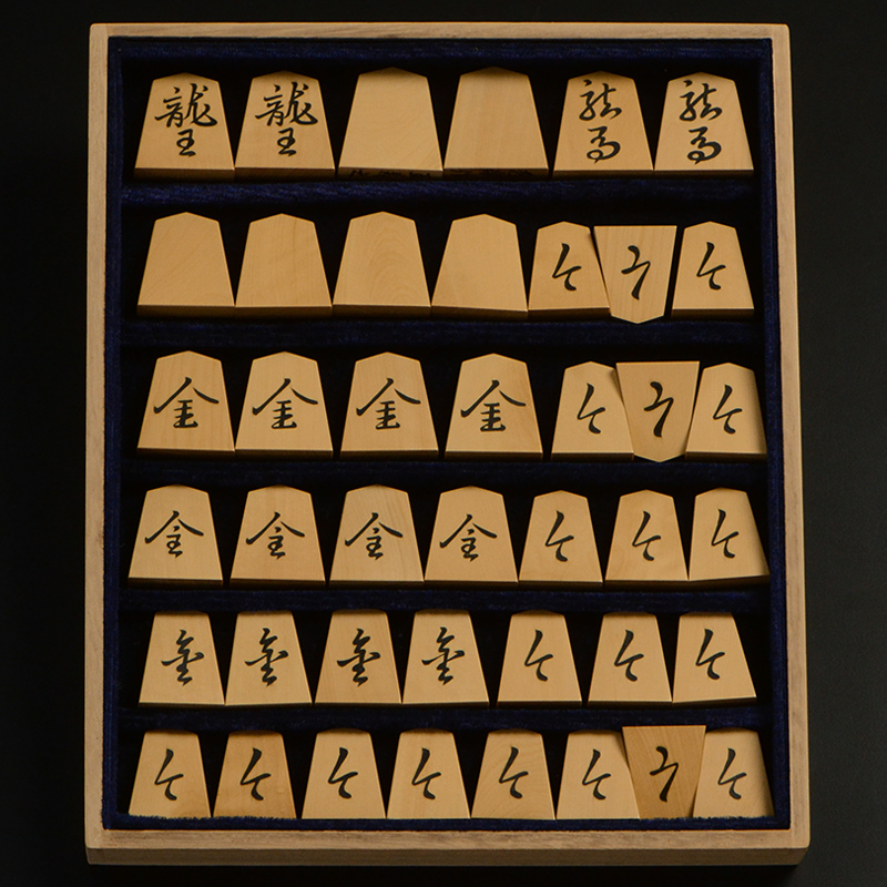 平箱に入った、裏返した将棋駒すべて