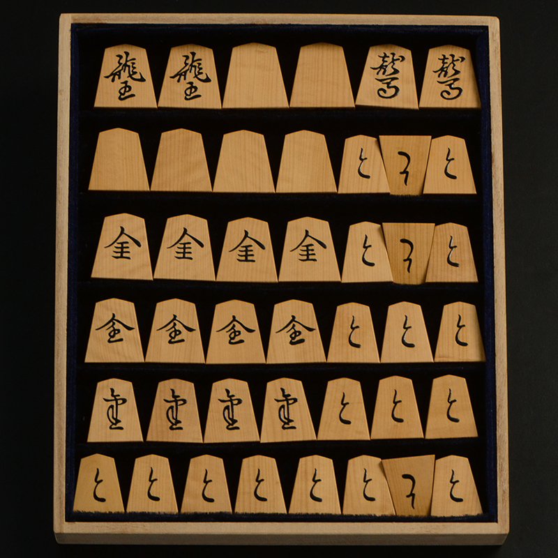 平箱に入った、裏返した将棋駒すべて
