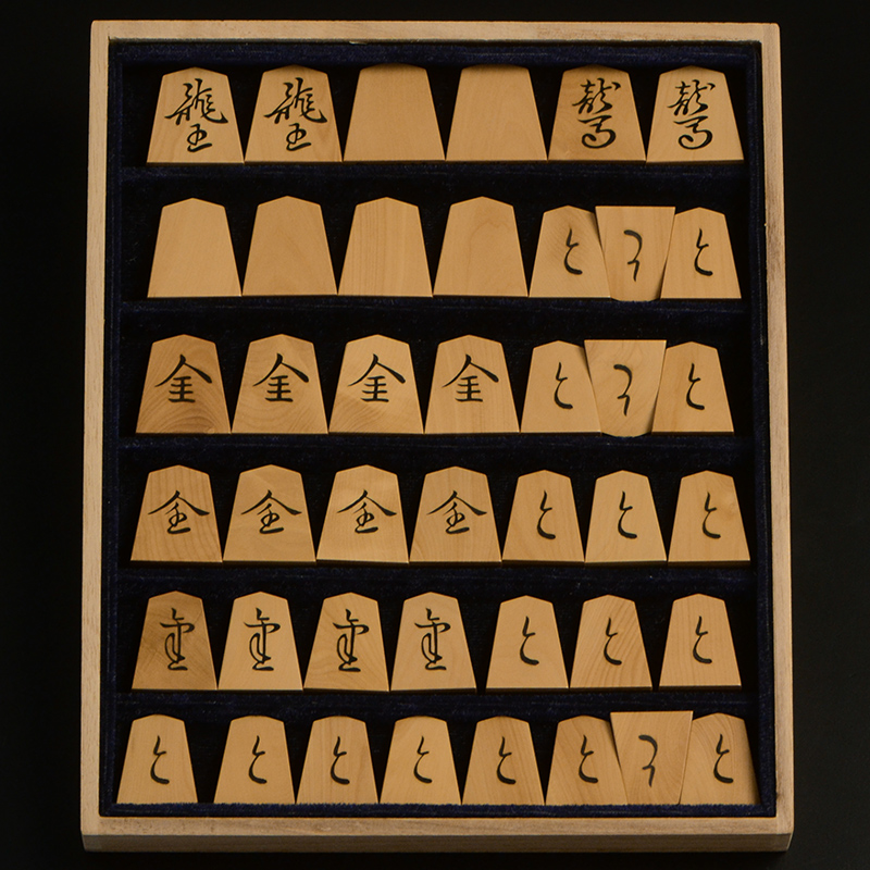 平箱に入った、裏返した将棋駒すべて