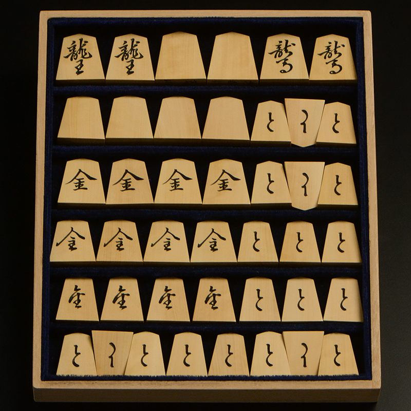 平箱に入った、裏返した将棋駒すべて
